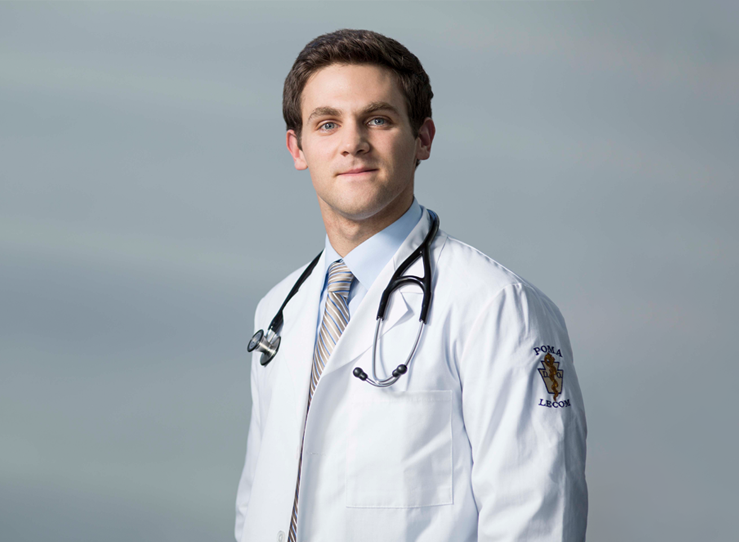 Young male medical student in white coat with stethoscope at LECOM